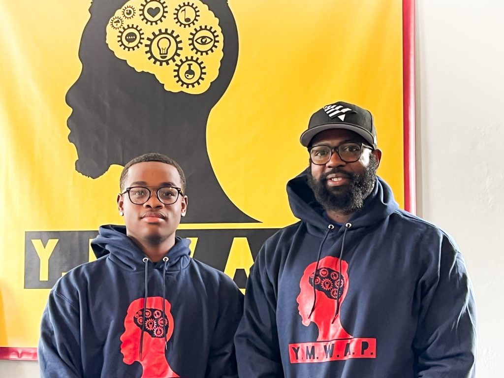 Two men smiling at the camera.