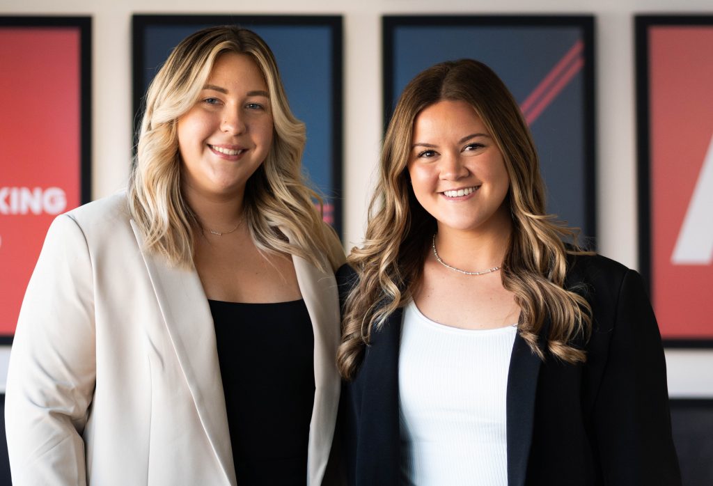 Two woman smiling at the camera.