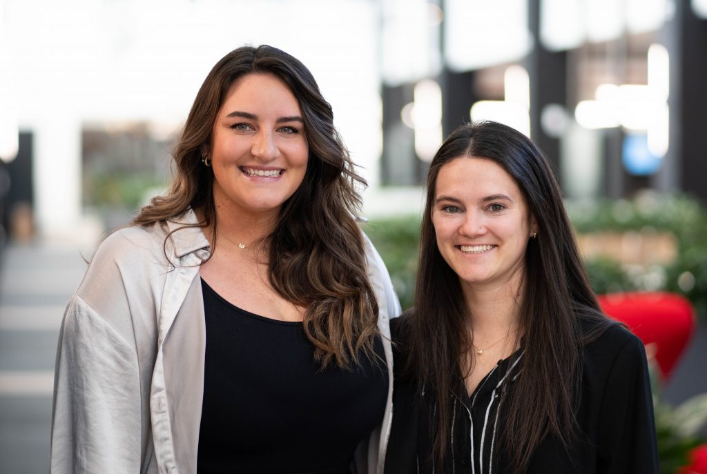 Two woman smiling at the camera.
